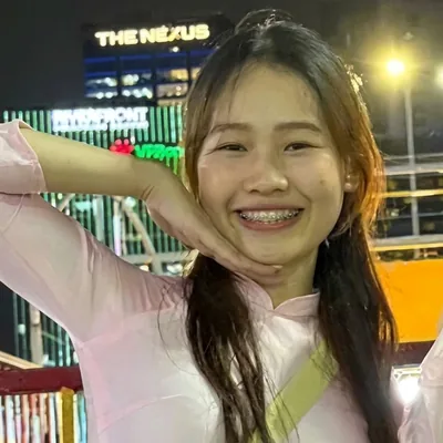 Clara, tour leader at Miss Saigon Tours, in a pink ao dai at night